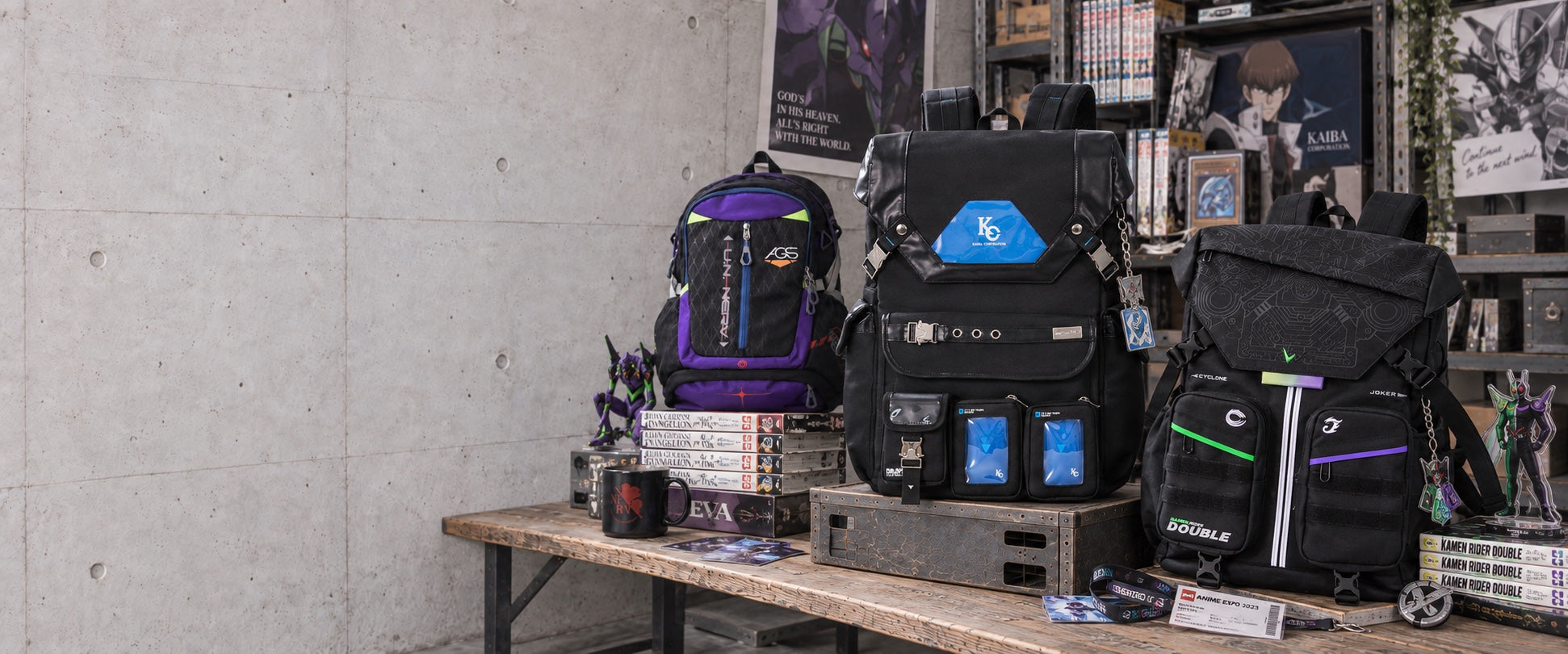 Evangelion, Kaiba Corp and Kamen Rider Double backpacks in a layered industrial anime fan room with manga, posters and convention keepsakes