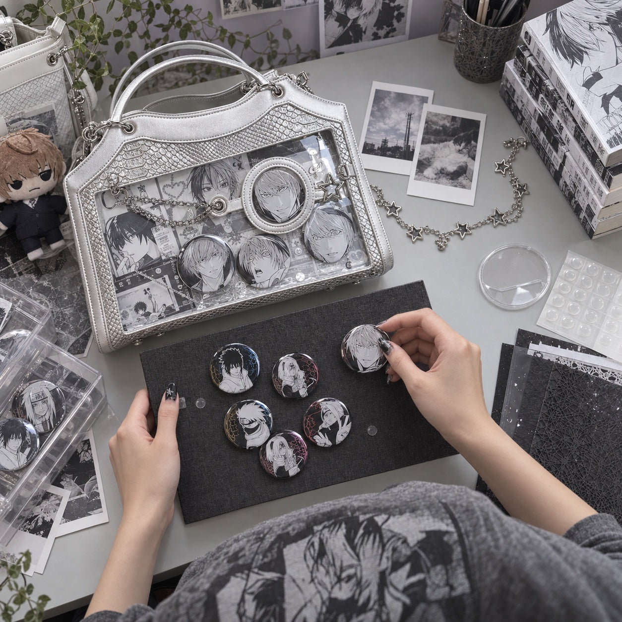 Hands arranging anime pins and insert boards beside a partly styled ita bag.